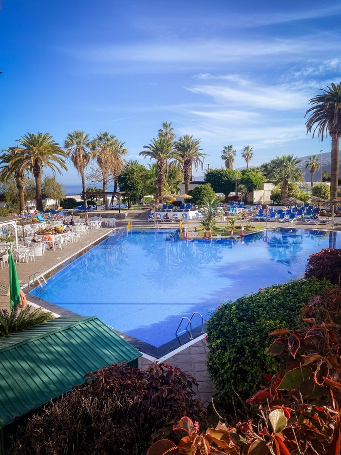 Serene tropical poolside view in Puerto de la Cruz, Canary Islands, Spain, perfect for a relaxing escape.